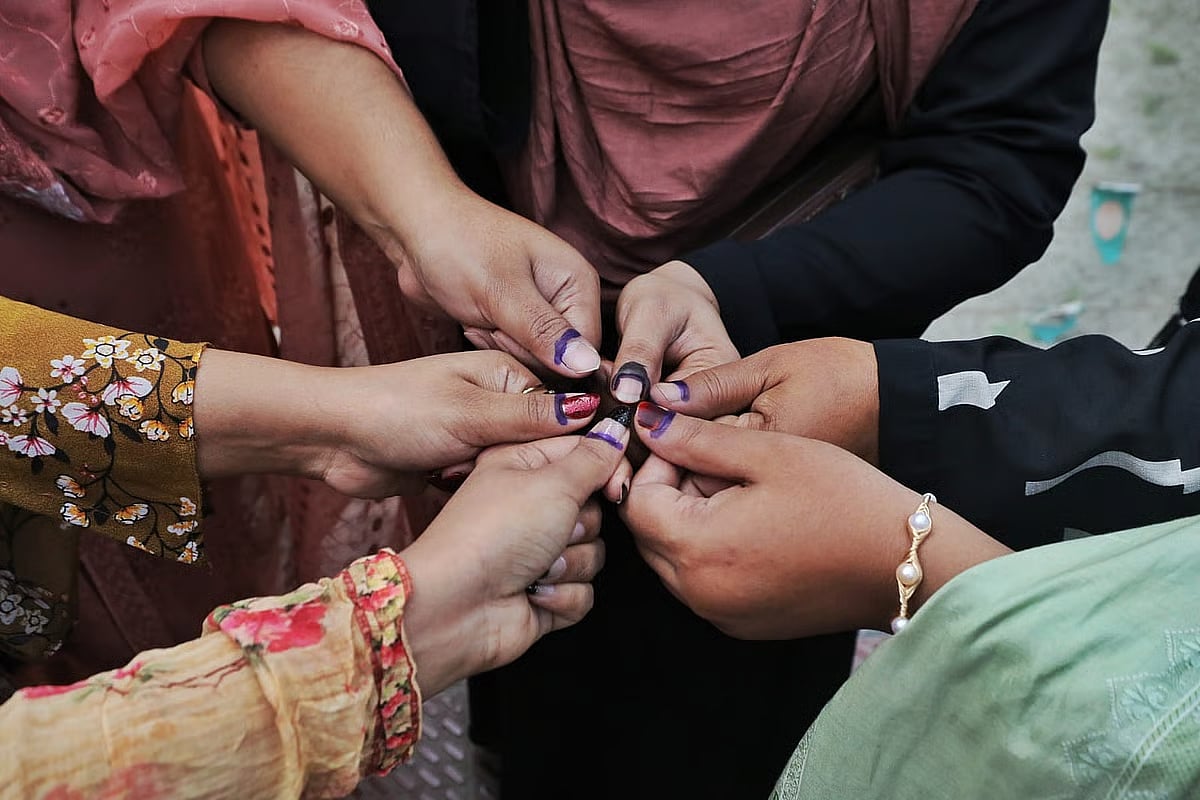 After casting their votes, several women voters pose for a photo holding their ink-marked fingers together. The photo was taken at the Dania College polling centre in Dhaka on 12 February 2026.