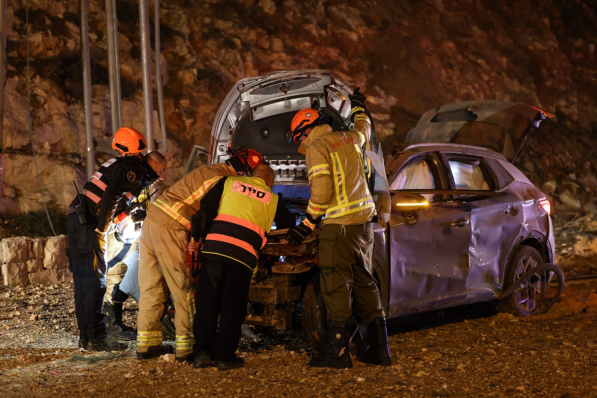 Israel security forces inspect a damaged car after a missile struck a road in Jerusalem on March 1, 2026. The United States and Israel launched strikes against Iran on February 28, killing Iran's supreme leader and top military leaders, prompting authorities to retaliate with strikes on Israel and US bases across the Gulf.