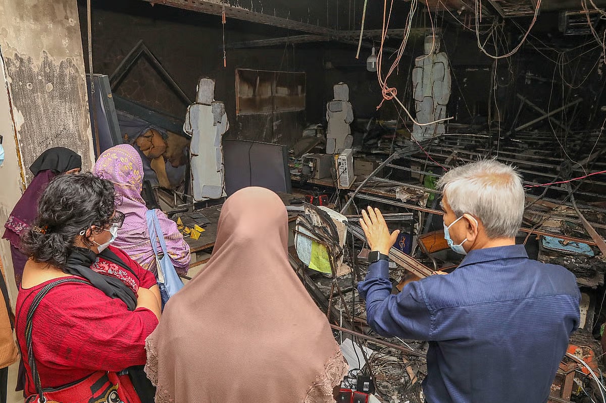 Visitors look at remnants of attacked and burned Prothom Alo building at art exhibition titled "Alo" on 2 March
