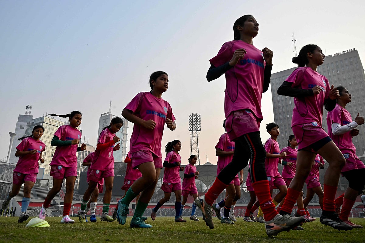 This photograph taken on 21 February, 2026 shows Bangladesh women's junior football team warming up during a training session at the National Stadium in Dhaka. Bangladesh's national football team face daunting odds at their first-ever Women's Asian Cup, but have already scored a major victory by qualifying. In the South Asian nation of 170 million, social stigma, family expectations, poverty and religious hardliners have long relegated women and girls to sports sidelines.