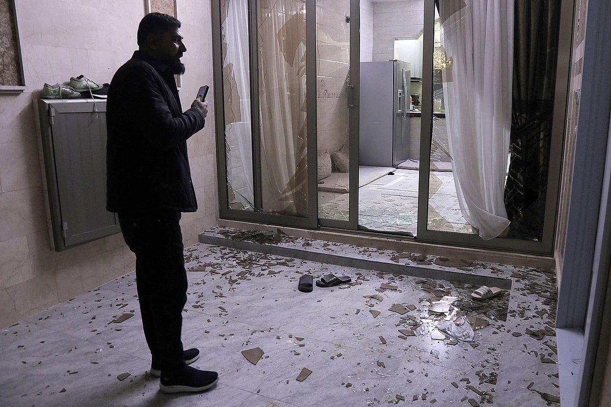 People inspect damage at a building whose windows were shattered followg air defences' interception of a projectile or drone over a residential neighbourhood in Arbil, the capital of Iraq's northern autonomous Kurdish region, on 5 March, 2026.