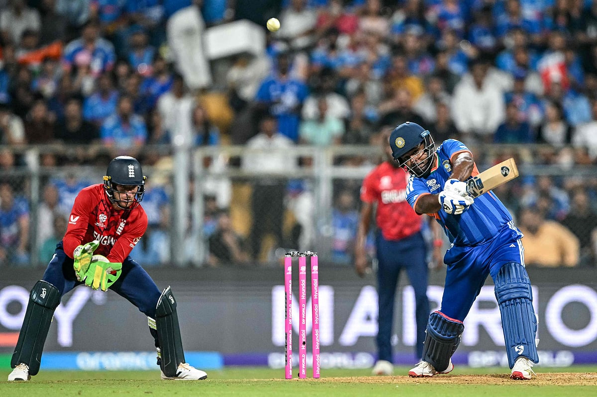 India's Sanju Samson (R) plays a shot as England's wicketkeeper Jos Buttler watches during the 2026 ICC Men's T20 Cricket World Cup semi-final match between India and England at the Wankhede Stadium in Mumbai on March 5, 2026.
