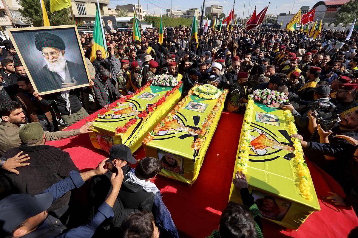 A mourner holds a portrait of Iran's slain supreme leader Ayatollah Ali Khamenei on 5 March 2026, during a funeral procession for members of Iraq's pro-Iran paramilitary group Hezbollah Brigades (Kataeb Hezbollah) who were killed in a strike in Baghdad the previous day.