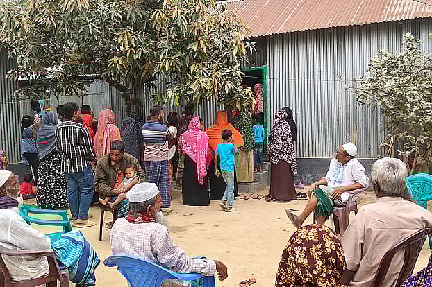 Crowds of neighbours and relatives gather at Mosharraf’s home. Monday.