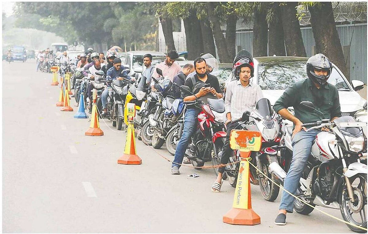 Motorcycle and cars wait in long lines to collect fuel. The queue stretches along the pavement from Bijoy Sarani intersection past Shaheen College, near the Prime Minister’s Office, around noon on 9 March 2026.