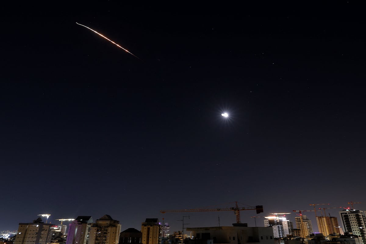Rocket trails are seen near the moon in the sky above the Israeli center coastal city of Netanya amid a fresh barrage of Iranian missile attacks on 11 March, 2026
