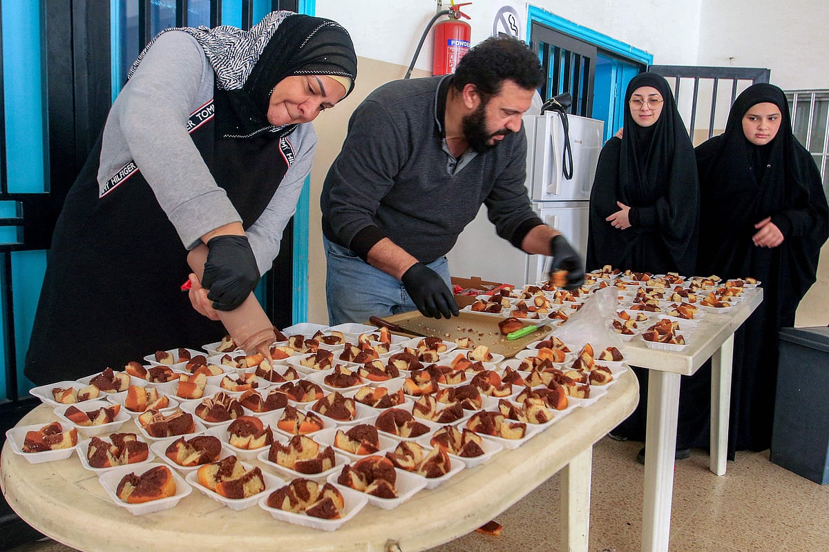 Volunteers prepare sweets for displaced people from southern Lebanon sheltering at a school in the southern coastal city of Sidon on March 17, 2026. After being forced to flee from Israeli air raids on southern Lebanon, families search in vain for alternative accommodations amid strict measures imposed by hotels and landlords afraid that guests might be targeted by Israel