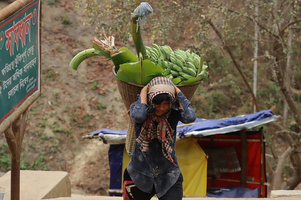 A man carries a bunch of bananas on his back to take them to the market for sale. Photo taken in the Shailaprapat area, Bandarban, 21 March.