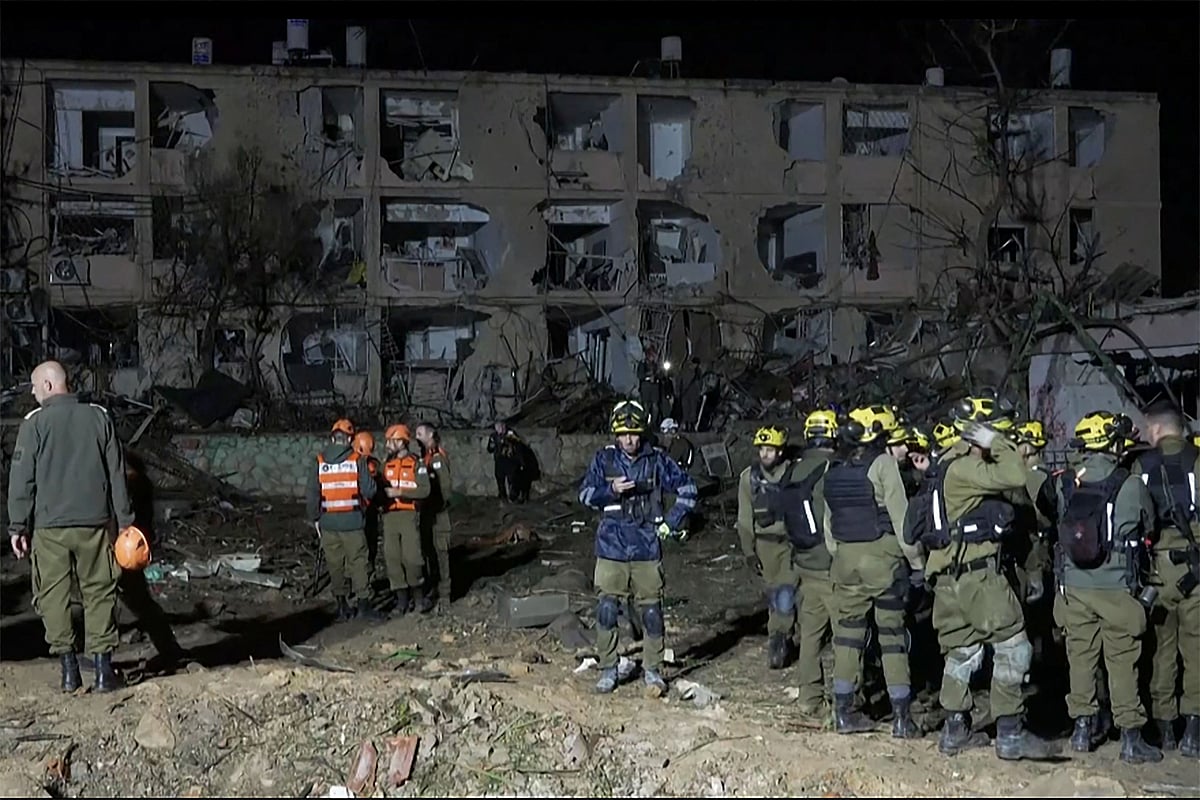 This frame grab from AFPTV footage shows first responders inspecting the site of an Iranian missile strike in Dimona on 21 March 2026
