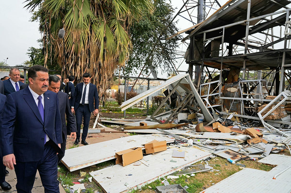 This handout photograph taken and released by the Iraqi Prime Minister's Press Office on March 22, 2026 shows Iraq's Prime Minister Mohammed Shia al-Sudani (L) inspecting the damage after a drone attack at an intelligence services building, in Baghdad.