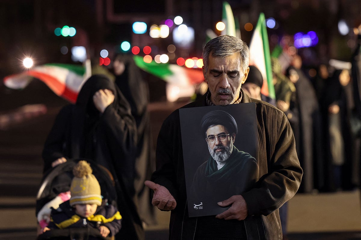A man reacts as he holds a portrait of Iran’s supreme leader Mojtaba Khamenei as people march in support of the Iranian armed forces in central Tehran on 25 March 2026