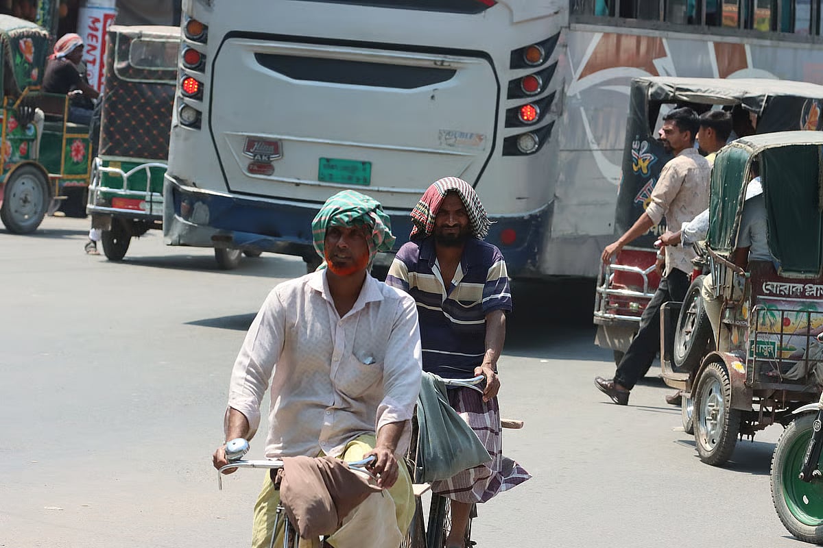 Bicyclists, seeking relief from the intense heat of the Bengali month of Chaitra, are seen riding with cloths wrapped around their heads to shield themselves from the scorching sun. The photograph was taken in the vicinity of Rajshahi Railway Station on 3 April 2026