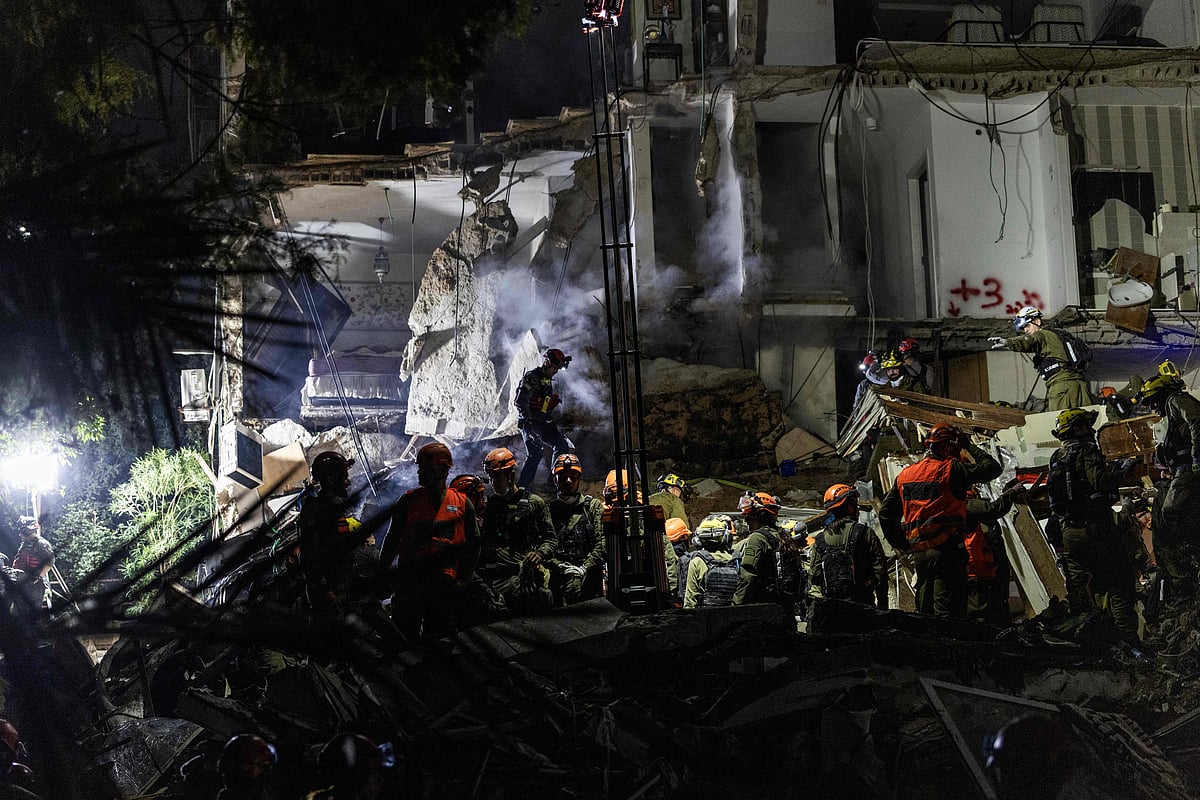 Israeli search and rescue personnel work at the site of a residential building destroyed in an Iranian strike in the northern city of Haifa on April 5, 2026. Israeli firefighters were searching for three missing people in the rubble of a residential building in the northern city of Haifa after it was struck by an Iranian missile April 5. The direct hit on a seven-storey building tore through parts of the structure, injuring four people, the military and rescue services said.