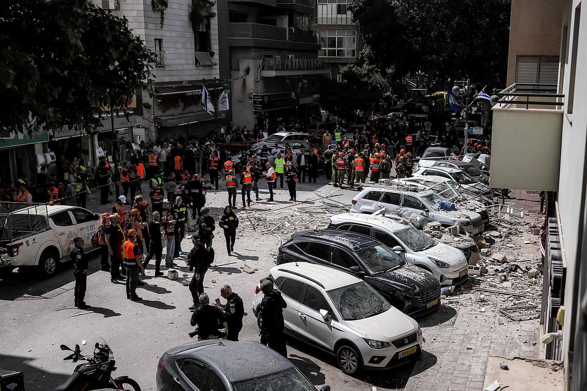 First responders gather along a street before a building that was hit by an Iranian projectile attack in Ramat Gan in central Israel on 6 April 2026.