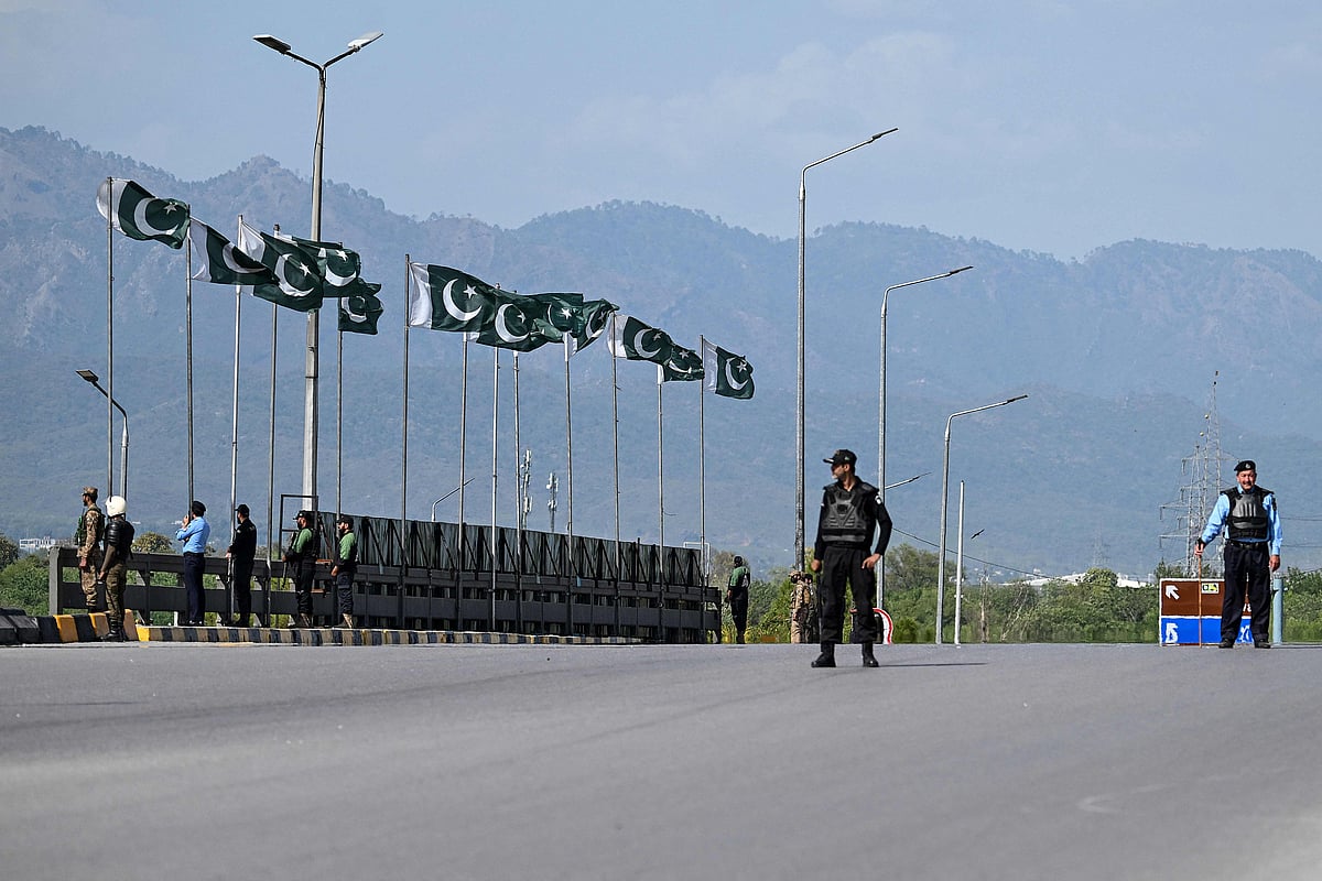 Security personnel stand guard on a bridge as a motorcade carrying US security officials makes its way toward the venue of the US–Iran talks in Islamabad on 10 April 2026