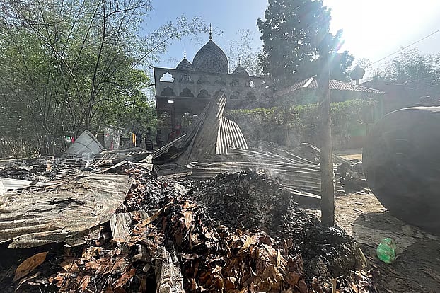 Smoke rises from the fire-scorched debris of the shrine in Philipnagar village of Philipnagar Union in Kushtia’s Daulatpur at 9:00am on Sunday.