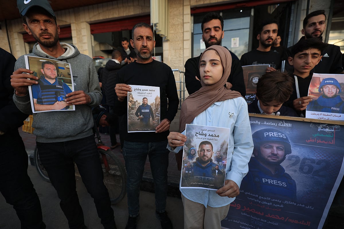 Fifteen-year-old Samia stands with Palestinians as they gather, holding images of her father, Mohammed Wishah, a journalist for the Qatar-based broadcaster Al-Jazeera Mubasher who was killed in an Israeli attack in the Bureij Refugee Camp on 8 April, during a solidarity rally in Deir al Balah in the Gaza Strip on 11 April, 2026. The Israeli military said on 9 April, 2026, that an Al Jazeera journalist killed a day earlier in an Israeli strike in Gaza was a Hamas militant who had "operated under the guise of a journalist".