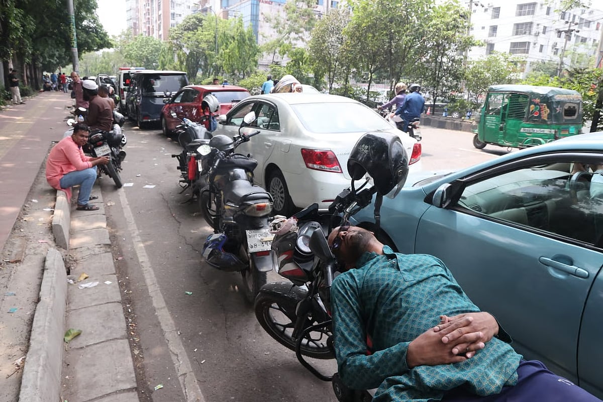 Spending hours in line for fuel, a man lies on his motorcycle and takes a nap while waiting in Asad Gate area of Dhaka on 17 April 2026.