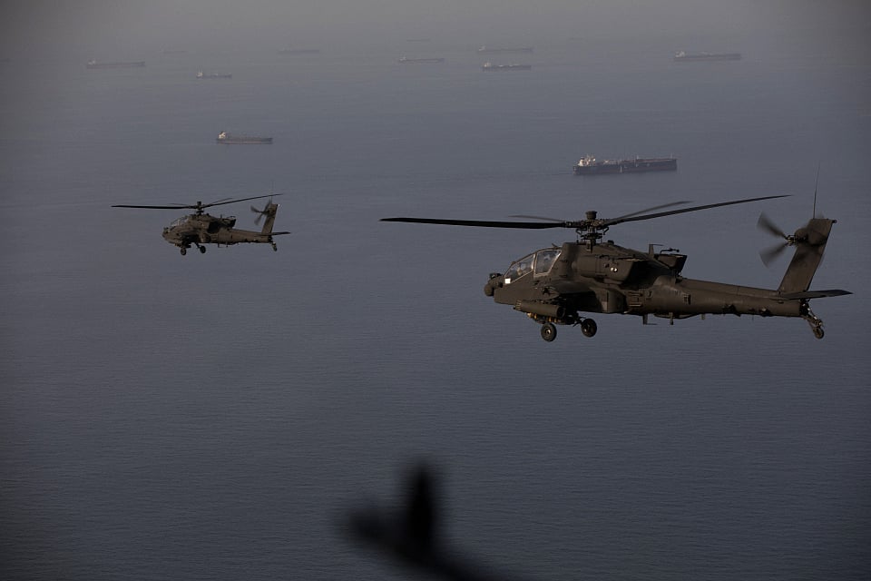 This handout photo released by US Central Command via their X account (@CENTCOM) on April 18, 2026 shows AH-64 Apaches flying above the Strait of Hormuz during a patrol on April 17, 2026