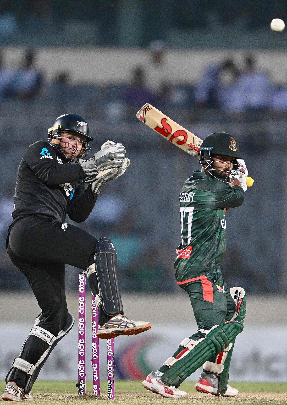 Bangladesh's Towhid Hridoy (R) plays a shot as New Zealand's wicketkeeper captain Tom Latham watches during the second one-day international (ODI) cricket match between Bangladesh and New Zealand at Sher-e-Bangla National Stadium in Mirpur on 20 April 2026. (Photo by Munir UZ ZAMAN / AFP)