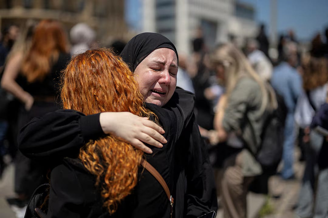 Women react as they hug each other while protesters, including members of the media, attend a vigil to condemn the killing of journalists, a day after journalist Amal Khalil was killed in an Israeli strike, in Martyrs' Square, Beirut, Lebanon 23 April, 2026.