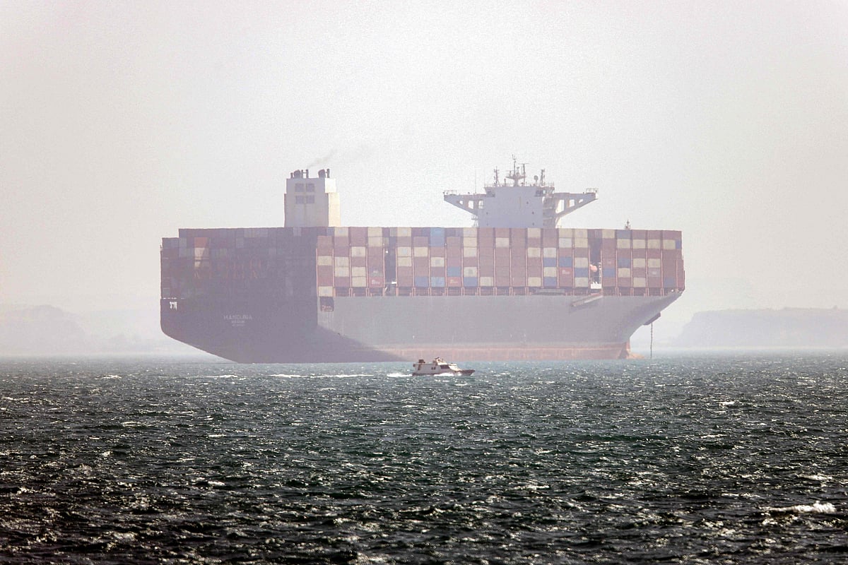 In this picture obtained from Iran’s ISNA news agency on 2 May 2026, the Iran-flagged container vessel Hamouna is pictured while anchored as a small motorboat passes by, in the Strait of Hormuz off Bandar Abbas in southern Iran