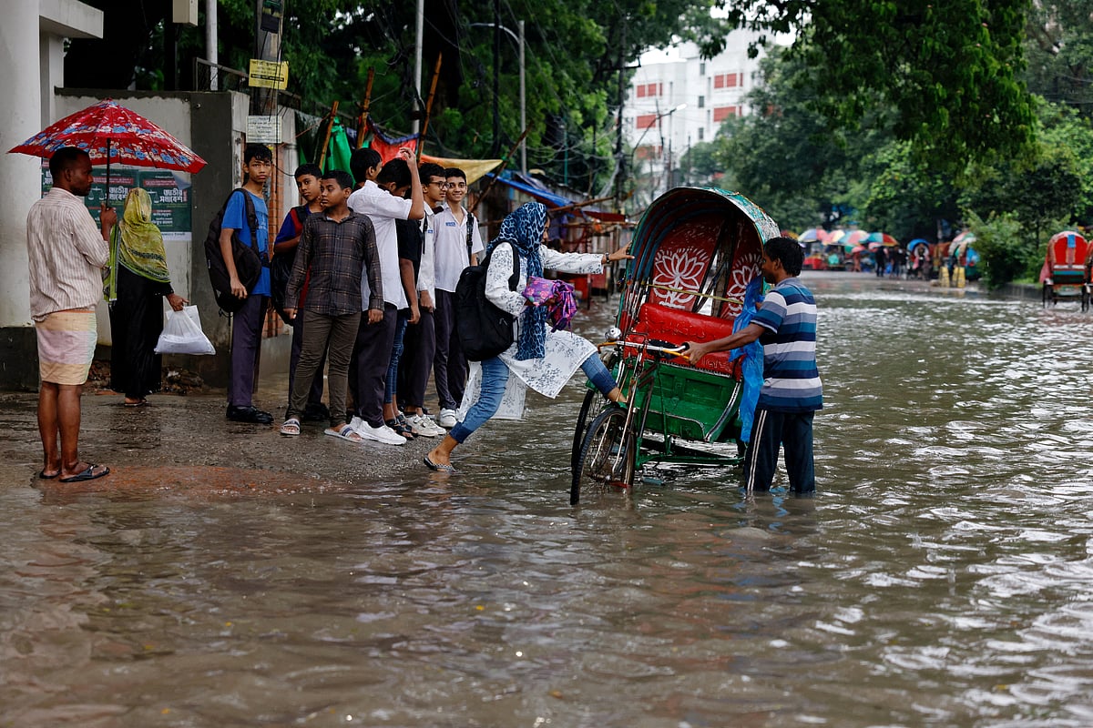 A girl gets on a rickshaw on a street flooded due to heavy rain, in Dhaka, Bangladesh, 15 July 2025.