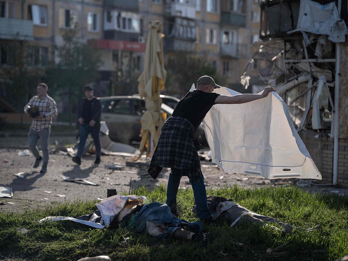 TOPSHOT - In this handout photograph taken and released on May 5, 2026 by the press service of the 93rd Kholodnyi Yar Separate Mechanized Brigade of the Ukrainian Ground Forces, a man covers the bodies of victims at the site of a Russian air attack, in Kramatorsk, the eastern Donetsk region, amid the Russian invasion of Ukraine. Russian attacks killed 21 people in cities across Ukraine on Tuesday, as President Volodymyr Zelensky condemned Moscow's "utter cynicism" for launching deadly strikes while seeking a truce to stage its May 9 patriotic parade. The attacks -- hitting the cities of Zaporizhzhia, Kramatorsk and Dnipro -- came hours before a Ukrainian-suggested ceasefire. (Photo by IRYNA RYBAKOVA / The 93rd Kholodnyi Yar Separate / AFP) / RESTRICTED TO EDITORIAL USE - MANDATORY CREDIT "AFP PHOTO / IRYNA RYBAKOVA / PRESS SERVICE OF THE 93RD KHOLODNYI YAR SEPARATE MECHANIZED BRIGADE" - NO MARKETING NO ADVERTISING CAMPAIGNS - DISTRIBUTED AS A SERVICE TO CLIENTS