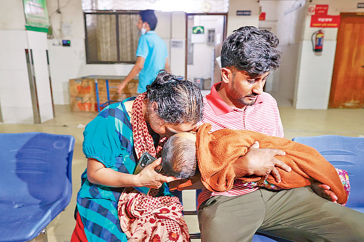 Shiuli Akter cries while holding her forehead against the lifeless body of her 10-month-old son, who died of measles, at the Infectious Diseases Hospital in Mohakhali, Dhaka, on May 8, 2026.