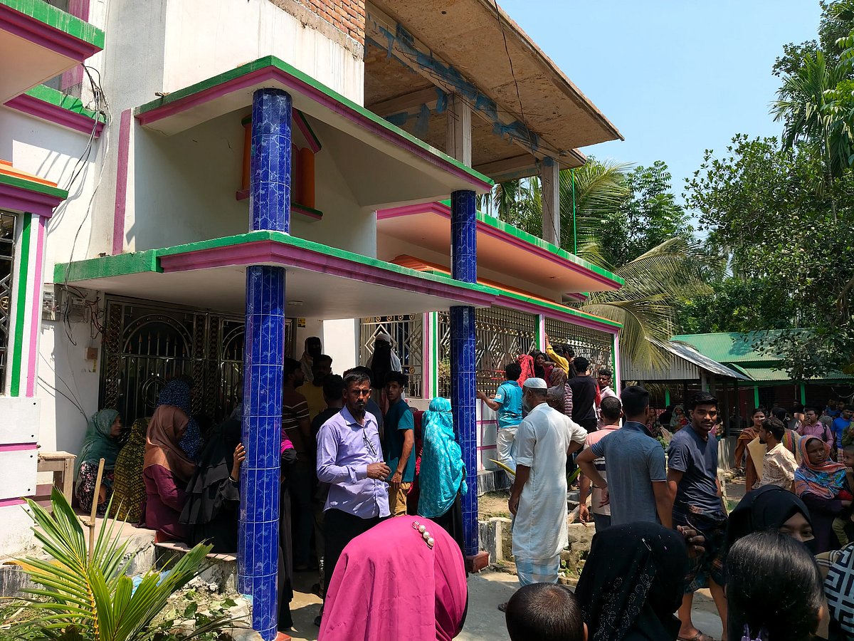 Relatives and locals gather in front of the house. Photo taken on Saturday.