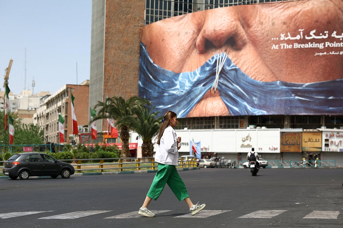 A woman walks past an anti-US billboard depicting US President Donald Trump and the Strait of Hormuz, in Tehran, Iran, 8 May, 2026.