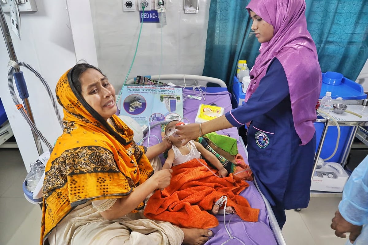 A woman breaks down in tears as her five-month-old baby with measles receives treatment at the intensive care unit (ICU) of the Bangladesh Neonatal Hospital in Signboard, Narayanganj on 12 May 2026.