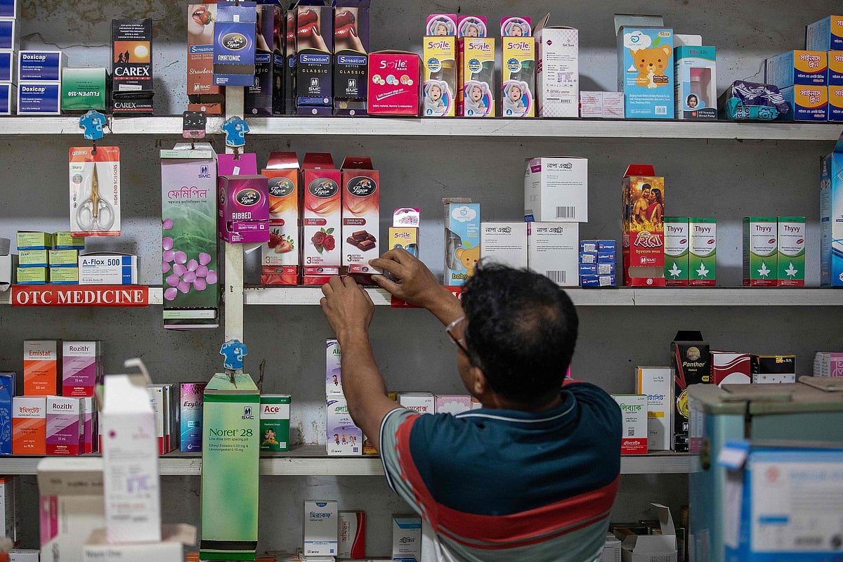 This photograph taken on 27 April 2026 shows a worker arranging packets of condoms at a pharmacy in Dhaka. Bangladesh’s once-praised family planning system is buckling under severe contraceptive shortages, raising fears of a rise in unplanned pregnancies in one of the world’s most densely populated countries