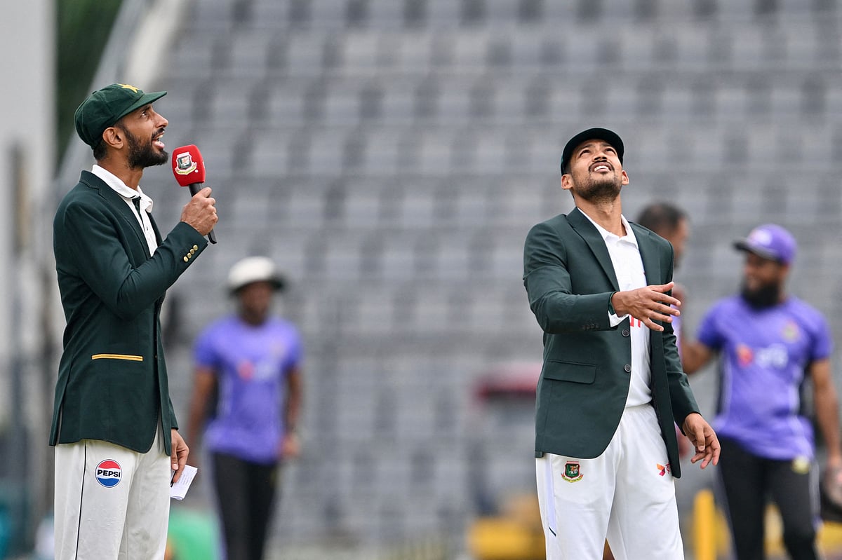 Bangladesh's captain Najmul Hossain Shanto (R) tosses a coin as Pakistan's captain Shan Masood (L) looks on before the start of play on the first day of the second Test cricket match between Bangladesh and Pakistan at Sylhet International Cricket Stadium in Sylhet on 16 May, 2026.