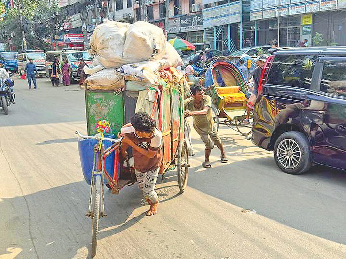 Two workers transport household waste to a temporary waste transfer station near Panthakunja Park in the capital’s Karwan Bazar area on 17 May 2026.