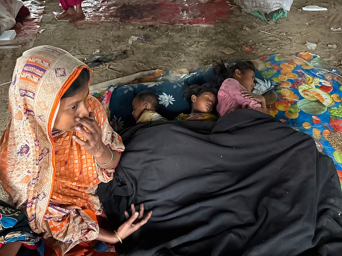 All of their belongings have been destroyed in a fire at the slum. Wrapping her three children in a blanket, this mother sits beneath the ramp of the Kalshi flyover. Photo taken on 26 May 2026.
