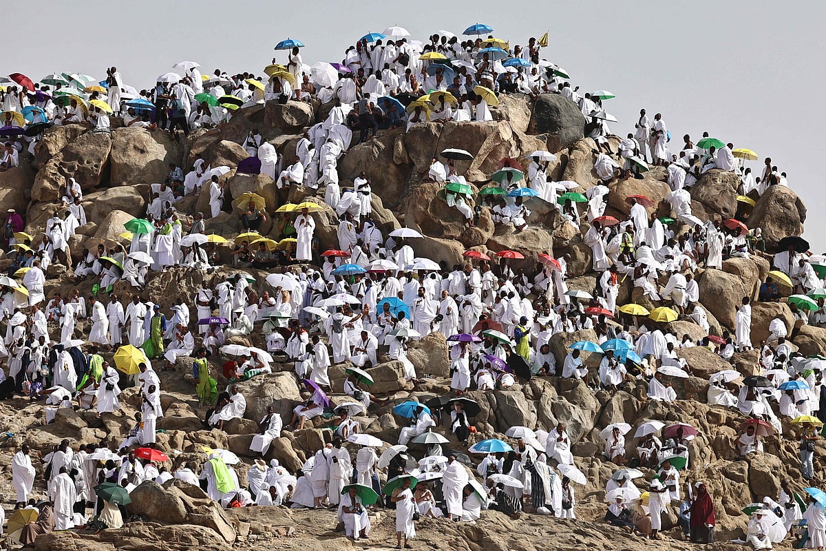 Muslim pilgrims pray on Saudi Arabia's Mount Arafat, also known as Jabal al-Rahma or Mount of Mercy, during the climax of the Hajj pilgrimage early on May 26, 2026.