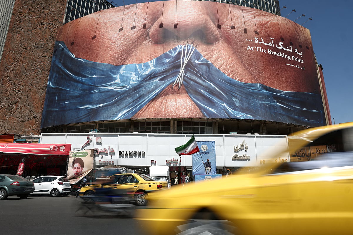 People ride past an anti-US billboard depicting US President Donald Trump and the Strait of Hormuz, in Tehran, Iran, 30 May, 2026.