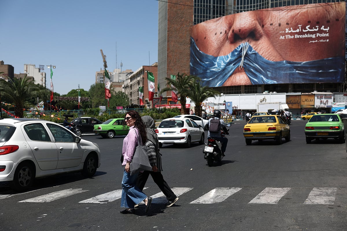 People walk past an anti-US billboard depicting US President Donald Trump and the Strait of Hormuz, in Tehran, Iran, on 30 May 2026