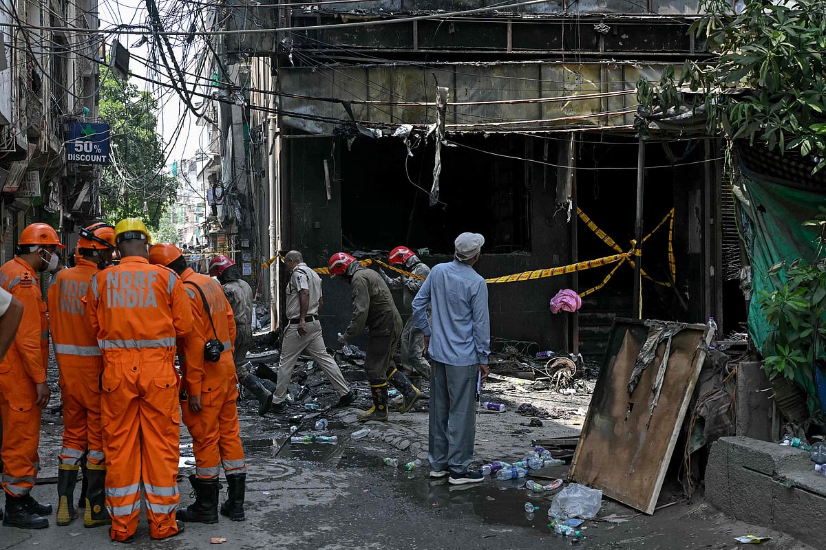 National Disaster Response Force (NDRF) personnel and firefighters stand at the site following a fire that broke out at a hotel in New Delhi on 3 June 2026