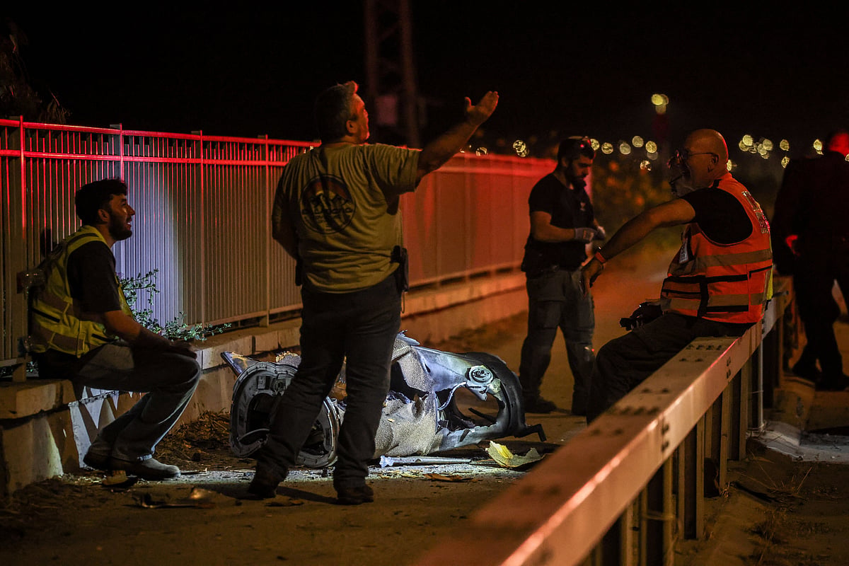 Israeli security and rescue personnel work next to a part of a projectile following a missile attack from Iran towards Israel in northern Israel, on 8 June 2026