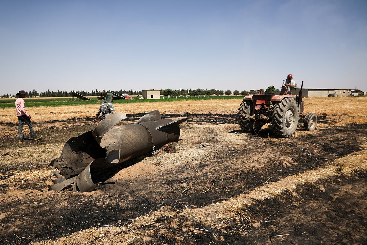 A farmer drags an Iranian missile, according to local authorities, with his tractor on his field after military engineering teams declared it safe, in the countryside near Damascus, Syria, on 9 June 2026