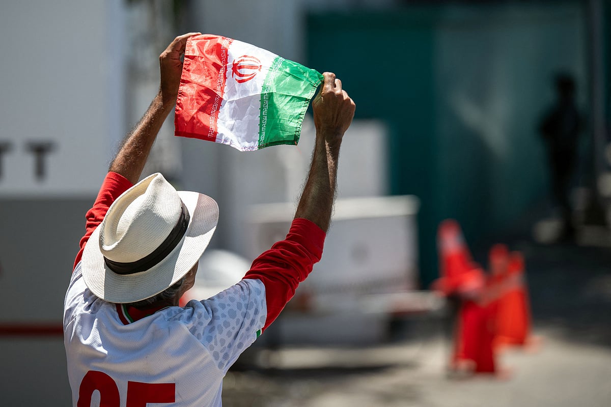 Iranian fan Reza Mansoor waves a national flag as he walks towards the Iran's base camp at the Marriott Hotel in Tijuana, Mexico on 9 June, 2026, ahead of the 2026 World Cup football tournament.