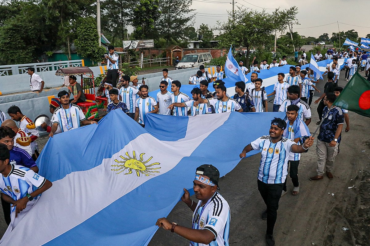 Supporters march along the roads of Purbachal carrying a giant Argentine flag.