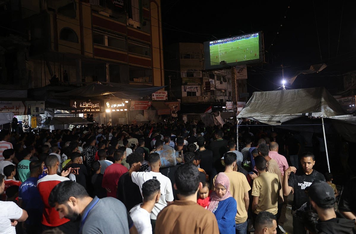 Palestinian football fans displaced from their homes which were destroyed by Israeli military strikes, watch the 2026 FIFA World Cup Group G match between Belgium and Egypt on a giant screen set up at the Nuseirat Refugee Camp in the central Gaza, on June 15, 2026.