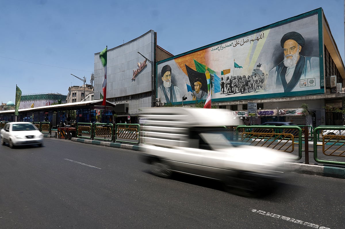 People drive past a mural depicting the late leader of the Islamic Revolution, Ayatollah Ruhollah Khomeini, and Iran's late Supreme Leader Ayatollah Ali Khamenei, on a street in Tehran, Iran, 14 June, 2026. 