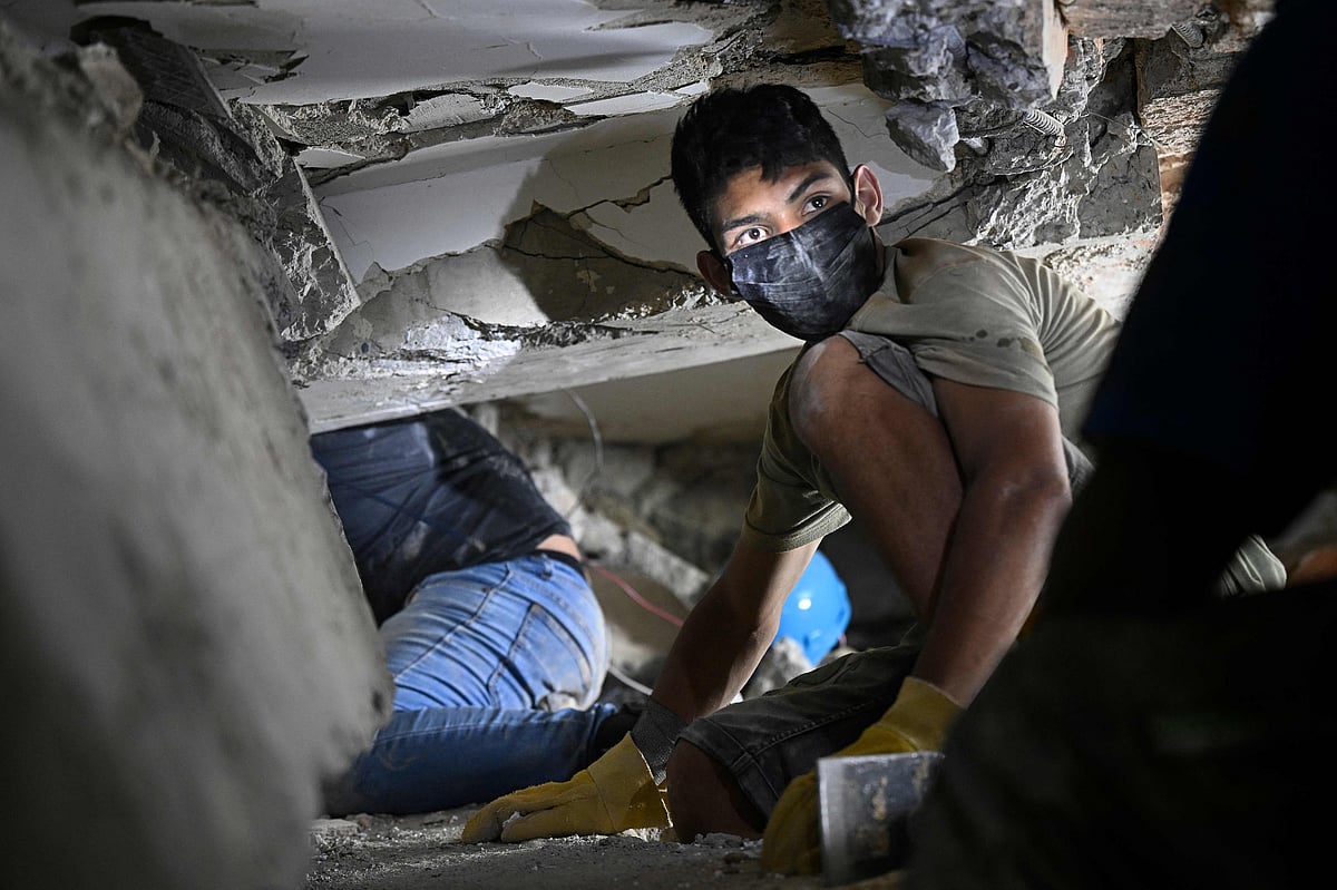 Rescuers search for possible victims at a collapsed building following the twin earthquakes, in Caraballeda, La Guaira State, some 40 km northeast of Caracas, on 27 June, 2026. The death toll in Venezuela's 24 June twin earthquake disaster reached 1,430, and millions more were feared to lack sanitation and other basic needs, as the first US aid flights landed in Caracas.