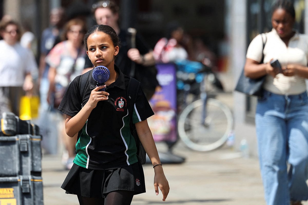 A girl uses a hand fan amid a heatwave, as Britain experiences record temperatures that disrupts schools and transport networks, in Manchester, Britain 26 June, 2026.