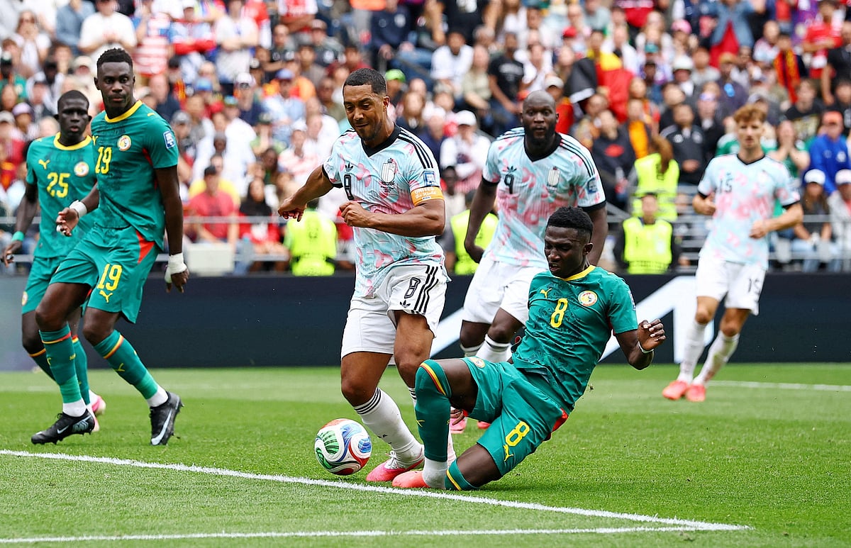 Senegal's Lamine Camara tackles Belgium's Youri Tielemans in the penalty area before a VAR review