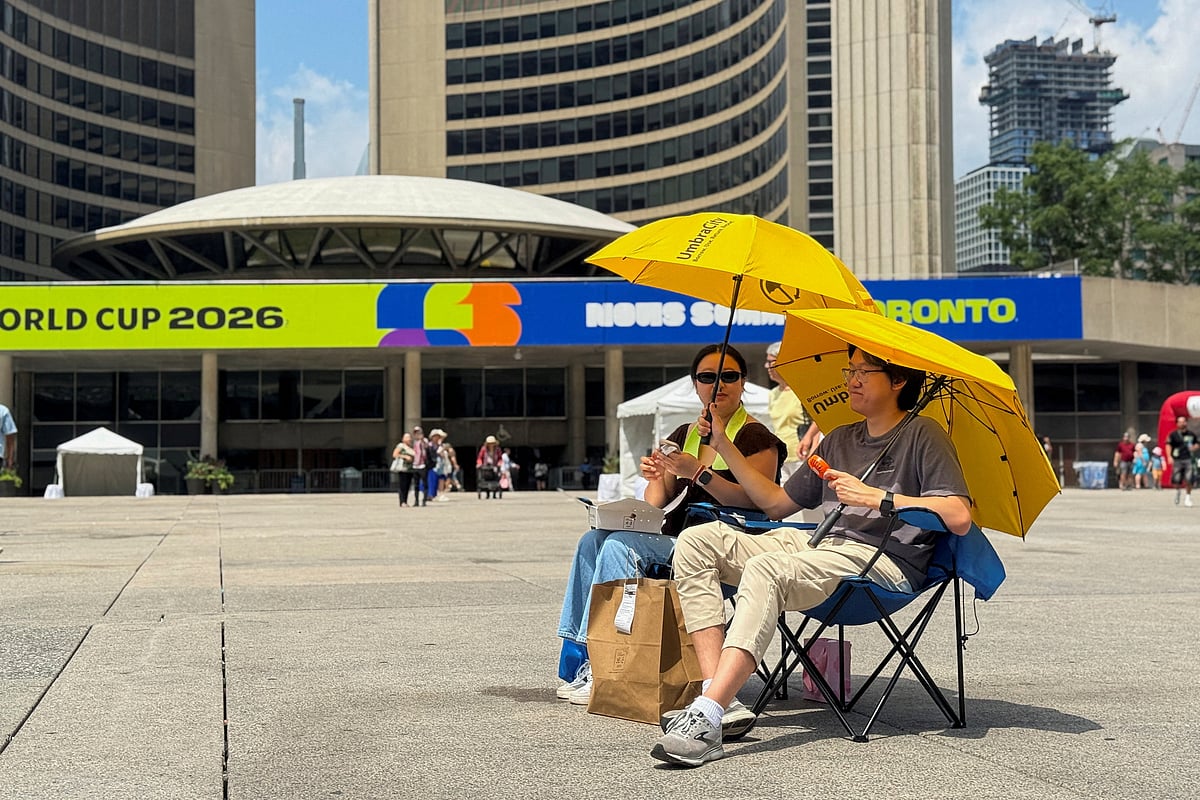 Two football fans watch the match between Ivory Coast and Norway at a fan zone in Nathan Phillips Square during hot weather in Toronto, Ontario, Canada, June 30, 2026.